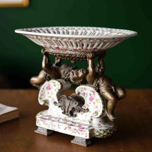Vintage jardinier with delicate floral patterned porcelain bowl and bronze angel figure