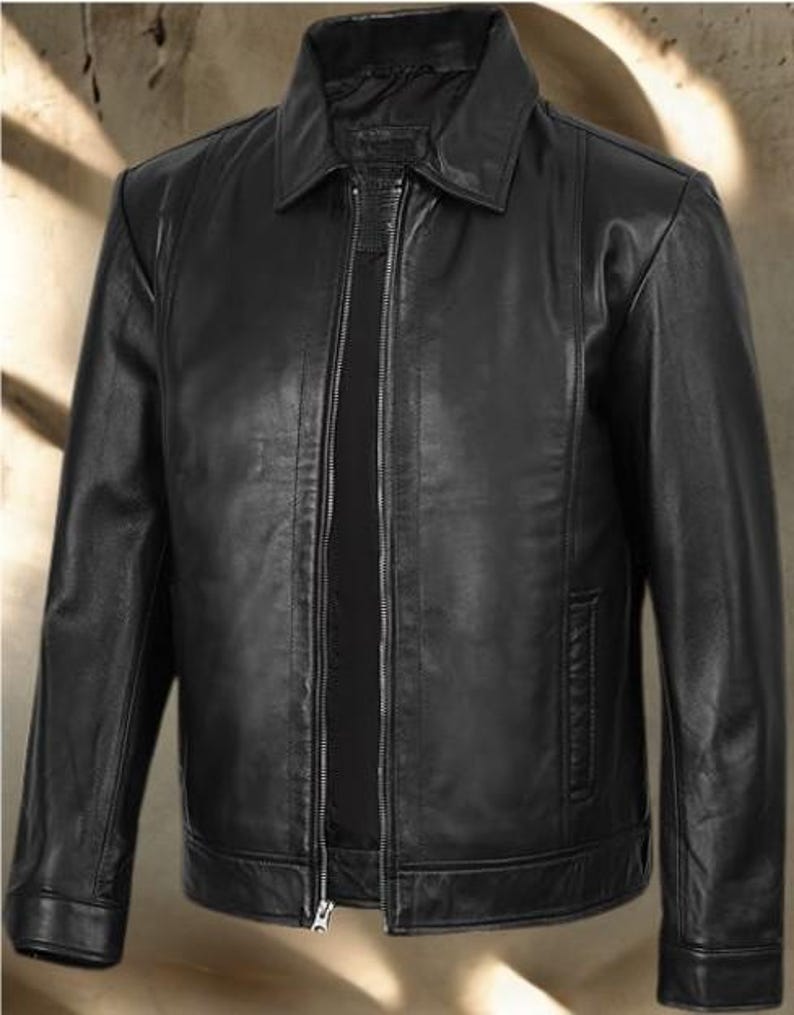 May include: A black leather jacket with a collared neckline and a full-length zipper closure. The jacket has a classic design with a tailored fit, featuring a small pocket on the chest and two side pockets. The jacket is made of a smooth, shiny leather material.