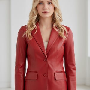 May include: A red leather blazer with a notched collar, two front pockets, and a two-button closure. The blazer has long sleeves and a tailored fit. The color is a vibrant, classic red.