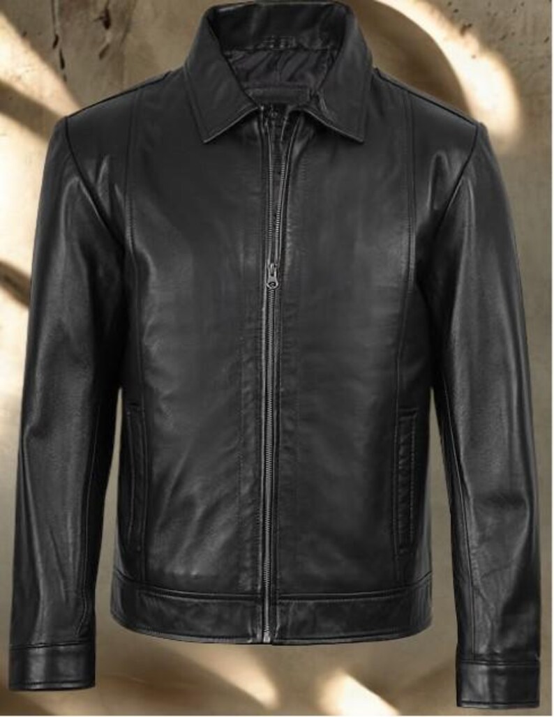 May include: A black leather jacket with a collared neckline and a full-length zipper closure. The jacket features long sleeves, a tailored fit, and a classic design. The jacket has a pocket on each side.