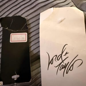 May include: A white tag with the text "Lord & Taylor" written in black cursive. A black tag with the number "$119.99" written in white.