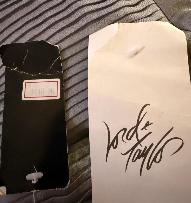 May include: A white tag with the text "Lord & Taylor" written in black cursive. A black tag with the number "$119.99" written in white.