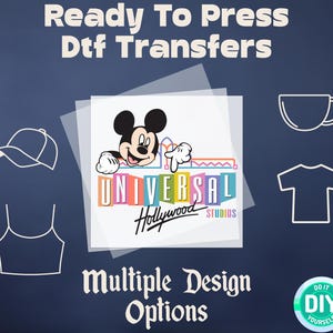 May include: A clear sheet of DTF transfer paper with a Mickey Mouse design featuring the Universal Studios Hollywood logo. The image is surrounded by outlines of various items that can be decorated with the transfer, including a t-shirt, a hat, a mug, and a tank top. The text "Ready To Press DTF Transfers" is at the top of the image, and the text "Multiple Design Options" is at the bottom of the image.