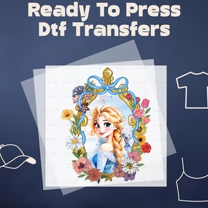 May include: A ready-to-press DTF transfer featuring a colorful illustration of a princess with blonde hair, wearing a blue dress, surrounded by flowers and a gold frame.
