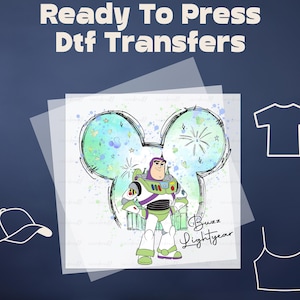 May include: A ready-to-press DTF transfer featuring a cartoon image of Buzz Lightyear from Toy Story. Buzz is standing in front of a green and blue watercolor background with a Mickey Mouse ear outline. The text "Buzz Lightyear" is written below the image.