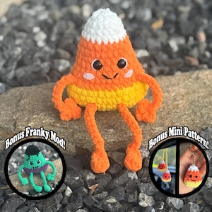 Puede incluir: Un personaje de caramelo de maíz tejido a ganchillo con una cara sonriente, brazos y piernas. El caramelo de maíz es naranja, amarillo y blanco. La imagen incluye el texto "PDF Crochet Pattern Only", "Bonus Franky Mod!" y "Bonus Mini Pattern!"