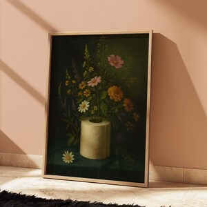 Puede incluir: Una impresi&oacute;n art&iacute;stica enmarcada que presenta un bodeg&oacute;n de flores coloridas en un jarr&oacute;n de rollo de papel higi&eacute;nico. Las flores incluyen margaritas, flores rosas y naranjas, y lavanda sobre un fondo verde oscuro. La obra de arte se muestra en un marco de madera clara.