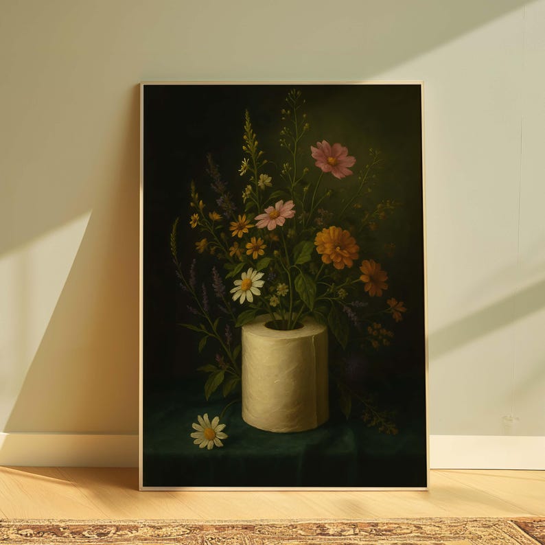 Puede incluir: Una impresi&oacute;n art&iacute;stica enmarcada que presenta un bodeg&oacute;n de flores coloridas dispuestas en un rollo de papel higi&eacute;nico. Las flores, en tonos rosas, naranjas y blancos, contrastan con un fondo oscuro. La obra se exhibe sobre una superficie verde.