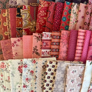 May include: An assortment of folded fabric pieces in diverse colours and patterns. The fabrics display floral, paisley, and geometric designs in shades of red, pink, blue, and purple. The arrangement showcases a variety of textures and styles.