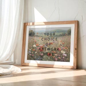 May include: A framed artwork featuring a vibrant field of wildflowers under a blue sky. The artwork is in a light wooden frame. Text on the artwork reads "YOUR CHOICE OF ARTWORK HERE". The artwork is leaning against a white wall.