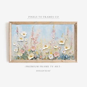 May include: A rectangular digital artwork for a television screen, framed in light wood, featuring an impasto-style painting of white and soft pink wildflowers against a pale blue background. Text reads PIXELS TO FRAMES CO, PREMIUM FRAME TV ART, FITS UP TO 85".