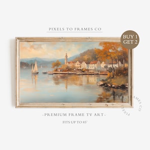 May include: A framed digital landscape painting for a TV screen featuring a lakeside village with a tall church tower, a sailboat on the water, and autumn trees. The text reads PIXELS TO FRAMES CO, BUY 1 GET 2, PREMIUM FRAME TV ART, FITS UP TO 85 INCHES.