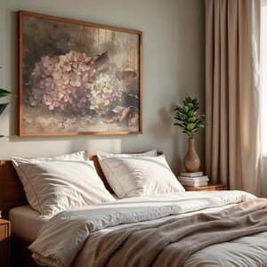 May include: A bedroom scene featuring a wooden bed with white bedding and a tan blanket. A framed floral painting hangs above the bed. A potted plant and a vase with greenery are on the nightstand. Beige curtains and a window are visible.