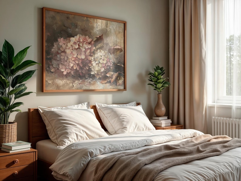 May include: A bedroom scene featuring a wooden bed with white bedding and a tan blanket. A framed floral painting hangs above the bed. A potted plant and a vase with greenery are on the nightstand. Beige curtains and a window are visible.