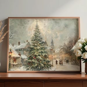 Peut inclure: Peinture encadr&eacute;e d'un paysage hivernal repr&eacute;sentant une place de ville enneig&eacute;e avec un sapin de No&euml;l d&eacute;cor&eacute;. L'&oelig;uvre pr&eacute;sente un clocher d'&eacute;glise, des lampadaires et des personnages marchant dans la neige. La peinture est dans un cadre en bois.
