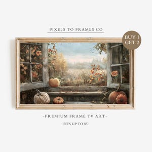 May include: A rectangular digital art display in a light wood frame featuring an autumn window scene with pumpkins, orange flowers, and a field. Text reads PIXELS TO FRAMES CO, BUY 1 GET 2, and PREMIUM FRAME TV ART FITS UP TO 85 INCHES.