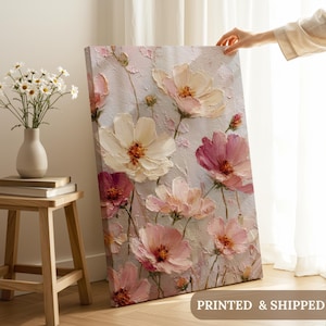 May include: A floral canvas print featuring large, textured flowers in shades of pink, cream, and burgundy against a light gray background. The artwork has a visible brushstroke effect, creating a three-dimensional appearance. The text "PRINTED & SHIPPED" is visible on the bottom right.