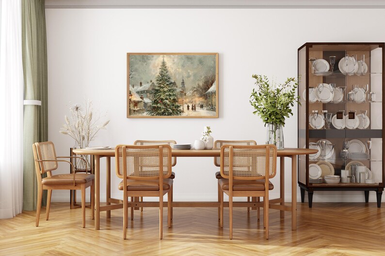 Peut inclure: Une salle &agrave; manger avec une table et des chaises en bois avec des dossiers en osier. Une peinture encadr&eacute;e d'un paysage d'hiver est accroch&eacute;e au-dessus de la table. Une vitrine en verre expose de la vaisselle et un vase de verdure ajoute une touche naturelle.