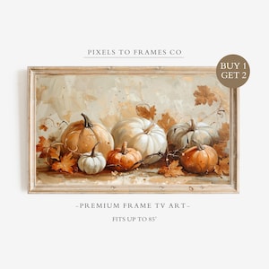 May include: A rectangular digital art print for a television featuring a still life of orange and white pumpkins surrounded by autumn leaves. The text PIXELS TO FRAMES CO, BUY 1 GET 2, and PREMIUM FRAME TV ART FITS UP TO 85" are visible.