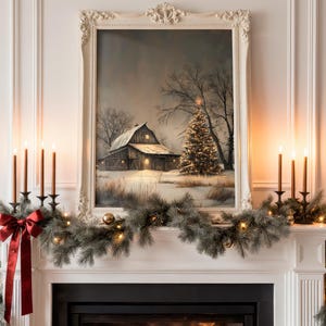 May include: A framed winter landscape painting of a barn and Christmas tree hangs above a fireplace. The mantel is decorated with a garland, candles, and a red bow. The painting is in a white ornate frame.