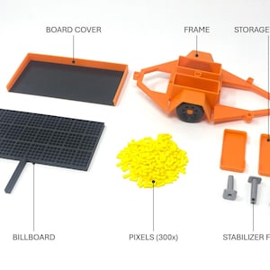 Pu&ograve; includere: Vista esplosa di un kit di modelli con vari componenti. Include un telaio arancione, un cartellone nero, un coperchio della tavola, coperture di stoccaggio, piedini stabilizzatori e pixel gialli. I componenti sono etichettati.