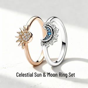 May include: A set of two rings, one gold-toned with a sunburst design and the other silver-toned with a crescent moon design. The sun ring features a central circle with small, clear stones. The moon ring has blue and clear stones. Text at the bottom reads "Celestial Sun & Moon Ring Set."