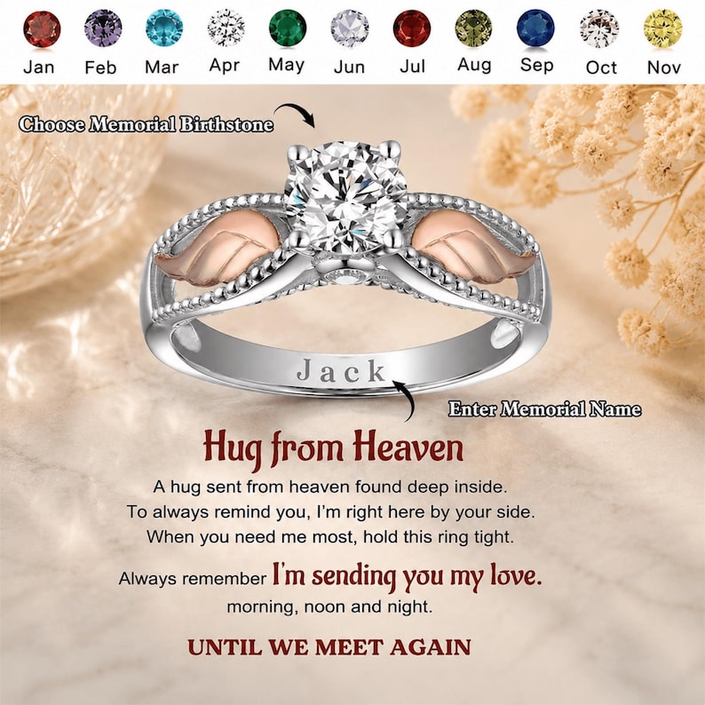 May include: A silver ring with a large, clear gemstone and rose gold accents. The ring features a wing design on each side of the gemstone. The word "Jack" is engraved on the band. The text "Hug from Heaven" is also visible.