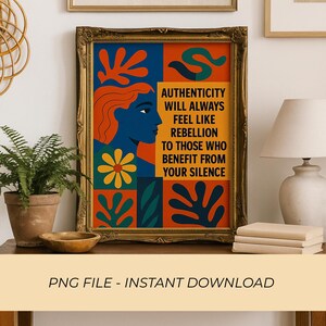 May include: A framed art print with a gold ornate frame. The artwork features a woman's profile in blue, orange hair, and abstract shapes in orange, blue, and green. Text reads: AUTHENTICITY WILL ALWAYS FEEL LIKE REBELLION TO THOSE WHO BENEFIT FROM YOUR SILENCE.
