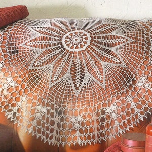 Peut inclure: Une nappe en crochet blanche avec un motif en étoile, posée sur une surface en cuir marron.