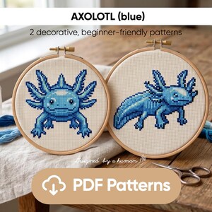 Könnte beinhalten: Zwei Kreuzstichmuster von blauen Axolotln in Holzreifen. Der Text "AXOLOTL (blau)" und "2 dekorative, anfängerfreundliche Muster" stehen oben. Der untere Teil des Bildes zeigt "PDF Patterns".