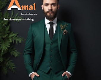 May include: A man wearing a dark green three-piece suit with a black tie and a small floral boutonniere. The suit is tailored and has a sharp, modern look. The man has a beard and is looking directly at the camera.