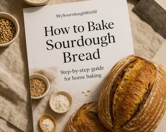 May include: A white book with the title "How to Bake Sourdough Bread" and a step-by-step guide for home baking. Two loaves of sourdough bread are shown on the cover.