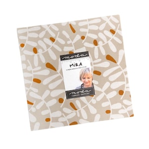 May include: A square fabric piece with a beige background and a repeating pattern of white leaf-like shapes and orange accents. A tag with the text "MIRA" and a woman's portrait is attached. The tag also includes the text "moda FABRICS + SUPPLIES".