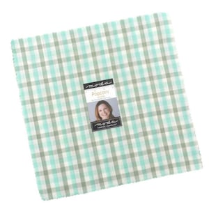 Puede incluir: Una pila cuadrada de cuadrados de tela con un patrón de cuadros en color verde azulado claro y gris. Una etiqueta central muestra el texto "moda", "Popcorn", "by Elizabeth Hartman" y "FABRICS + SUPPLIES" junto a la foto de una persona.