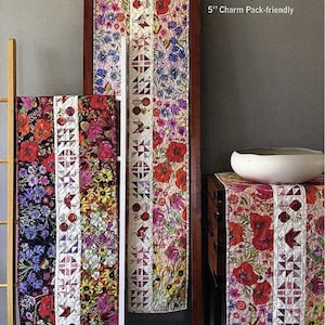 May include: Floral table runners in various lengths, displayed on a wooden ladder. The runners feature colorful flower patterns with red, purple, and yellow blooms. The text reads "CENTERPIECED" and "16 1/2" wide TABLE RUNNER in three lengths".
