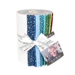 May include: A fabric roll with a selection of blue, green, and white patterned fabrics. The roll is tied with a white ribbon printed with measurements and a tag with the text "MODA FABRICS - SUPPLIES".