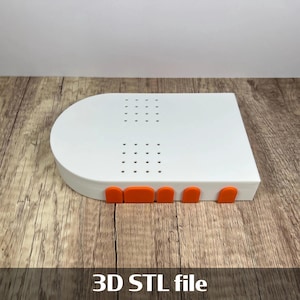 May include: A white, rectangular 3D printed object with a rounded top and orange accents. The object has several small holes on the top surface and the text "3D STL file" at the bottom.