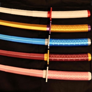 May include: An assortment of colorful toy swords. The swords have white, gold, blue, red, and pink blades with matching handles. Each sword has a different color handle and guard. The blades have a diamond pattern.