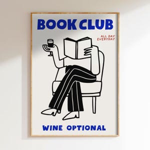 Op de afbeelding: Een ingelijste kunstdruk met de woorden "BOOK CLUB" in blauw boven een illustratie van een persoon die een boek leest en een wijnglas vasthoudt. De tekst "ALL DAY EVERYDAY" is rood en "WINE OPTIONAL" is blauw.