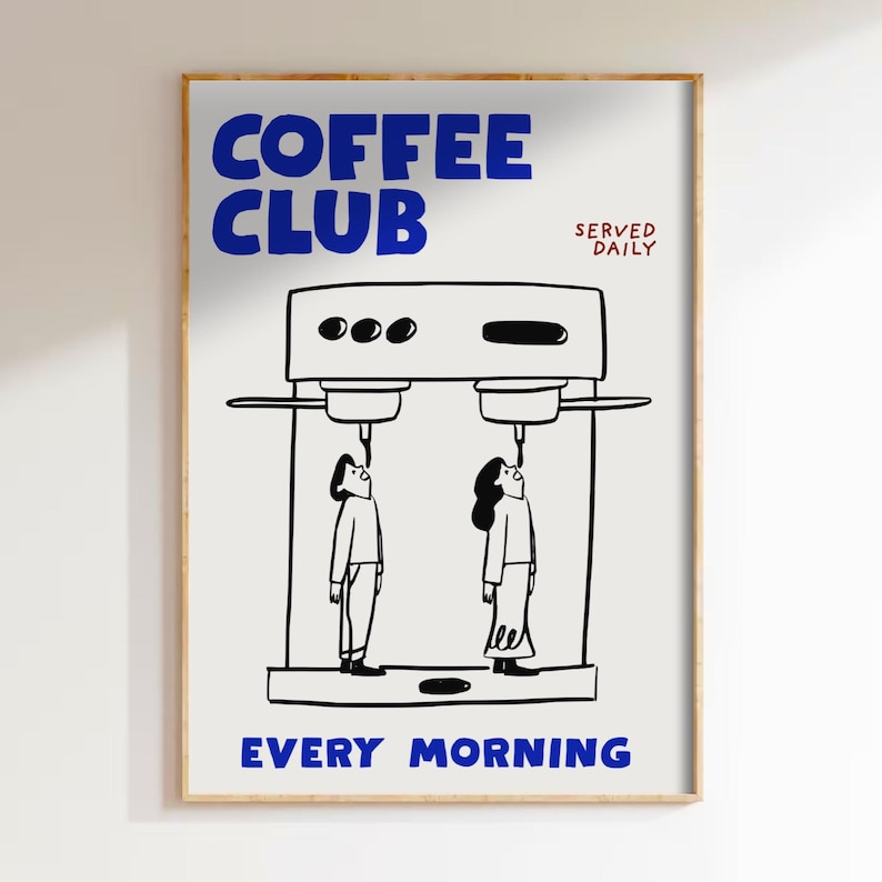 May include: A framed art print with a coffee theme. The words "COFFEE CLUB" in blue are at the top, with "SERVED DAILY" in red. Below is a black and white illustration of a coffee machine with two people looking up at it. The words "EVERY MORNING" are at the bottom.
