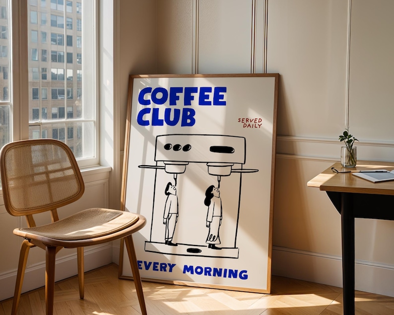 May include: A framed poster with the words "COFFEE CLUB" in blue, and the text "SERVED DAILY EVERY MORNING". The poster features a black and white illustration of a coffee machine and two people.