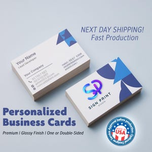 May include: Two stacks of white business cards with blue and purple geometric designs. The cards feature the text "Your Name, Lead Developer" and "Your Company". The image also includes the text "Personalized Business Cards" and "Sign Print Studio".
