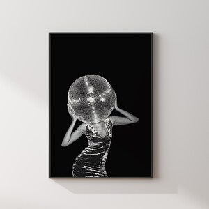 May include: Black and white art print featuring a person with a disco ball head. The person is wearing a velvet dress. The background is solid black, creating a striking contrast.