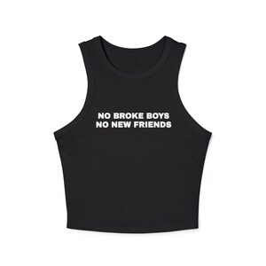 Może przedstawiać: Czarny top z napisem "NO BROKE BOYS NO NEW FRIENDS" w białych literach. Top ma okrągły dekolt i krój bez rękawów.