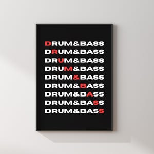 Puede incluir: Impresión artística enmarcada en negro con la frase "DRUM&BASS" repetida verticalmente. El texto alterna entre blanco y rojo, creando un contraste llamativo. La obra de arte se muestra sobre un fondo neutro.