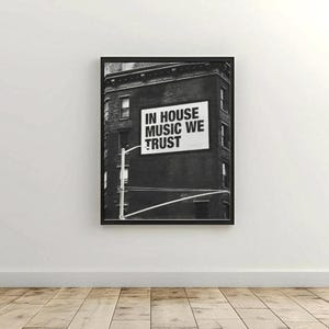 May include: Black and white framed print featuring a building with a sign that reads "IN HOUSE MUSIC WE TRUST". The image is a photograph of a building with a sign on the side.