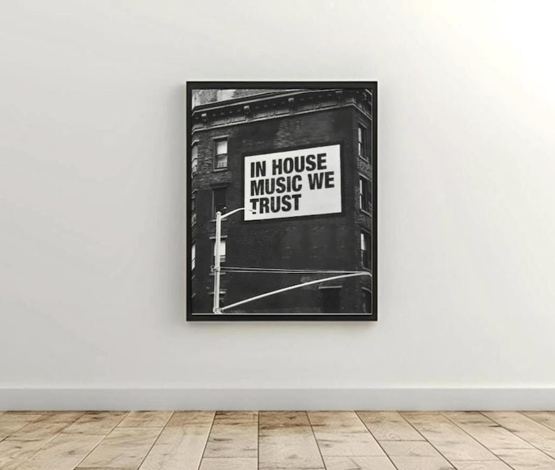 May include: Black and white framed print featuring a building with a sign that reads "IN HOUSE MUSIC WE TRUST". The image is a photograph of a building with a sign on the side.
