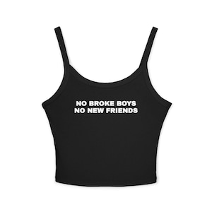 Może przedstawiać: Czarny top z cienkimi ramiączkami. Tekst "NO BROKE BOYS NO NEW FRIENDS" jest wydrukowany na białym tle z przodu. Top jest w jednolitym czarnym kolorze.