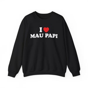 May include: Black crew neck sweatshirt with the text "I ♥ MAU PAPI" in white block letters and a red heart. The sweatshirt is a solid black color and has long sleeves.