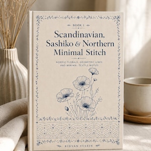 May include: A hardcover book titled Scandinavian, Sashiko & Northern Minimal Stitch by Ridvan Yusein. The cream-colored cover features dark blue text and a line-art illustration of flowers above a geometric pattern, all framed by a floral border.